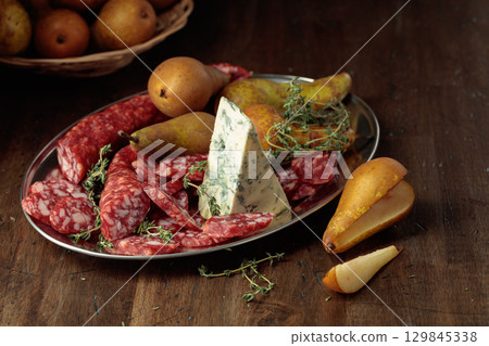 Dry-cured sausages, blue cheese, thyme and pears. 129845338