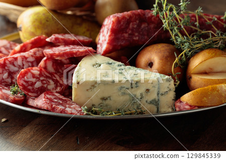 Dry-cured sausages, blue cheese, thyme and pears. Dry-cured sausages, blue cheese, thyme and pears. 129845339