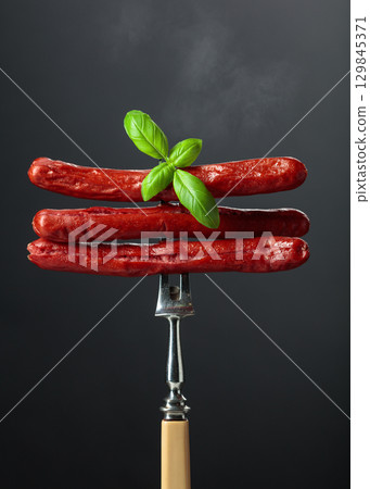 Thin grilled sausages with basil. 129845371