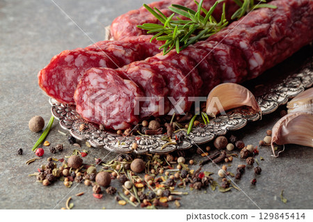 Sliced smoked sausage on a small silver tray. Sliced smoked sausage on a small silver tray. 129845414
