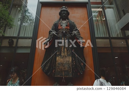 Elegant sculpture of bodhisattva exhibited on a facade in a modern building 129846084
