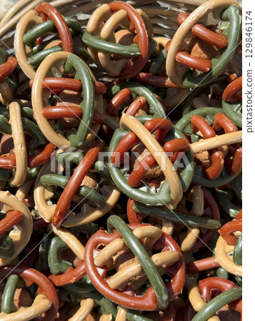 Woven basket brimming with vibrant dog treats, creating a delightful assortment of textures and flavors, perfect for rewarding furry friends during training or playtime 129846174