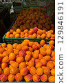 Vibrant orange and red apricots pile high in green crates, creating a colorful and abundant display at a local farmers market, showcasing the bounty of summer harvest 129846191