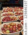 Cardboard containers overflowing with ripe, red and yellow gooseberries create a vibrant display at a local farmers market, showcasing the abundance of fresh, seasonal produce 129846197