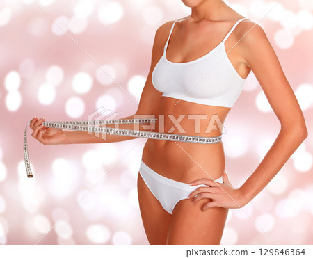 Lady with a tape measure on an abstract background 129846364