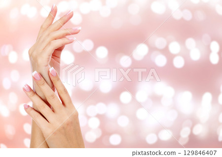 Beautiful woman hands against an abstract background Beautiful woman hands against an abstract background 129846407