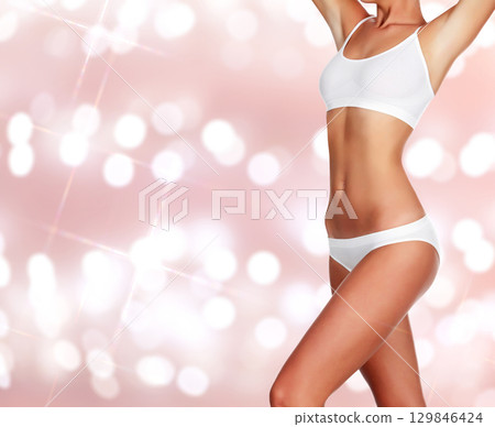Slim woman body on an abstract background with blurred lights 129846424