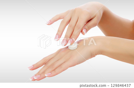 Female hands with a moisturiser on light grey background 129846437