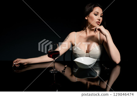 Woman enjoys spaghetti in a studio setting with elegant lighting 129846474