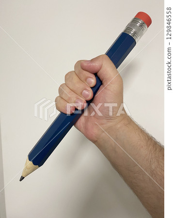 Hand holding a huge pencil Hand holding a huge pencil 129846558