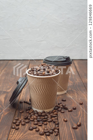 Paper cup with coffee beans. Takeaway coffee concept. Modern lifestyle. Close-up 129846669