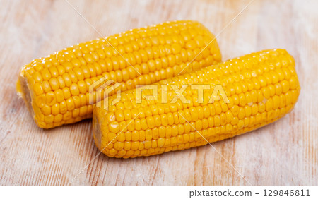 Two cooked corncobs 129846811
