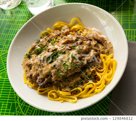 Pork ribs with mushroom sauce and linguine 129846812