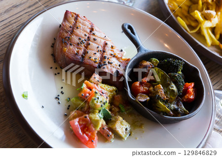 Grilled tuna steak with avocado and tomatoes Grilled tuna steak with avocado and tomatoes 129846829