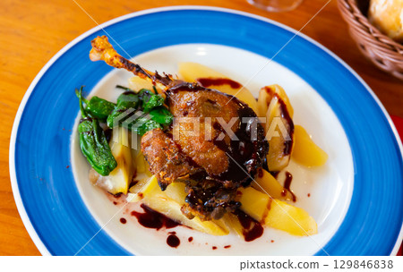 Duck confit in port with pear chutney 129846838