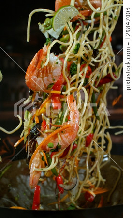 Freeze Motion of Flying Asian Wok Ingredients with Fire Flames 129847003