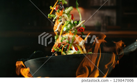 Freeze Motion of Flying Asian Wok Ingredients with Fire Flames Freeze Motion of Flying Asian Wok Ingredients with Fire Flames 129847006