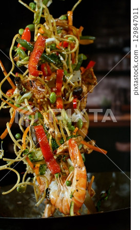 Freeze Motion of Flying Asian Wok Ingredients with Fire Flames 129847011