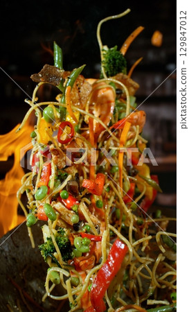 Freeze Motion of Flying Asian Wok Ingredients with Fire Flames Freeze Motion of Flying Asian Wok Ingredients with Fire Flames 129847012