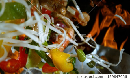 Freeze Motion of Flying Asian Wok Ingredients with Fire Flames 129847036