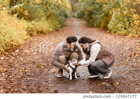 Happy Couple Walking Dog on Forest Trail Happy Couple Walking Dog on Forest Trail 129847177