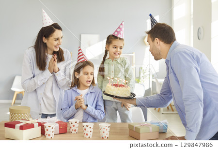 Happy birthday candle cake celebration, friendly family, parents and children party together Happy birthday candle cake celebration, friendly family, parents and children party together 129847986