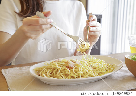 Woman eating delicious pasta 129849924