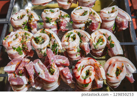 Marinated pork belly skewers with herbs prepared for grilling. Marinated pork belly skewers with herbs prepared for grilling. 129850253