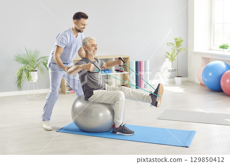 Doctor And Nurse Leading Senior Patient In Rehabilitation Sport Exercises 129850412