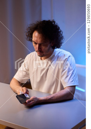 Cleaning a smartphone screen with a tissue needs attention for optimal hygiene and care 129850693