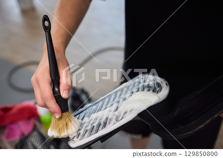The thorough and effective cleaning process of a car part involves foam and a brush technique 129850800
