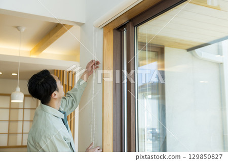 一名身穿工作服的男子在屋內工作 129850827