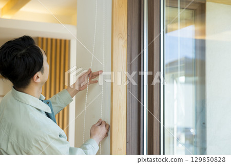 一名身穿工作服的男子在屋內工作 129850828