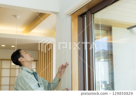 一名身穿工作服的男子在屋內工作 129850829