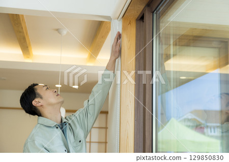 一名身穿工作服的男子在屋內工作 129850830