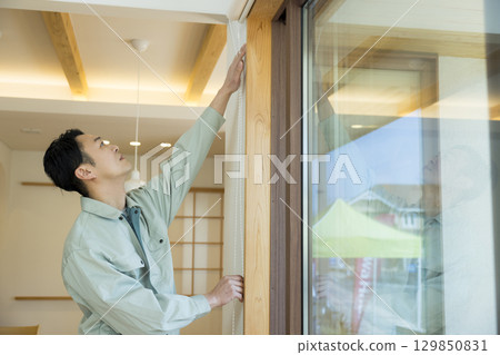 一名身穿工作服的男子在屋內工作 129850831