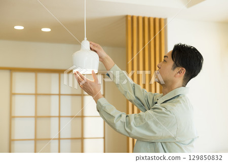 一名身穿工作服的男子在屋內工作 一名身穿工作服的男子在屋內工作 129850832