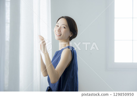 女人打開窗簾 129850950