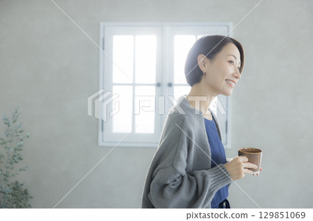 A woman drinking coffee 129851069
