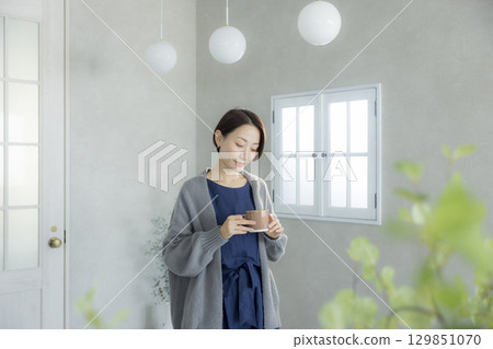 A woman drinking coffee 129851070
