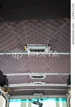 This is an Interior View of a Vehicle Ceiling which features Upholstered Panels and Structure 129851150