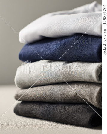 Stack of folded cotton sweatshirts neatly arranged, evokes sense of calm and order. soft fabric hints at comfort and casual style for relaxation 129851204