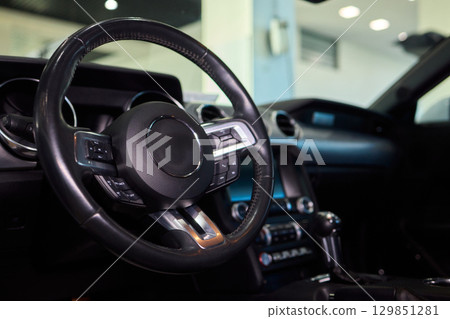 Closeup of a modern car steering wheel with control buttons for technology and convenience Closeup of a modern car steering wheel with control buttons for technology and convenience 129851281