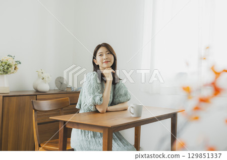 Young woman drinking coffee in her room Young woman drinking coffee in her room 129851337