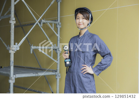 在建築工地工作的年輕女工 在建築工地工作的年輕女工 129851432