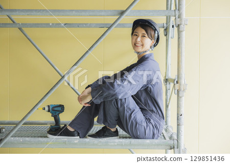 Young female worker working at a construction site 129851436