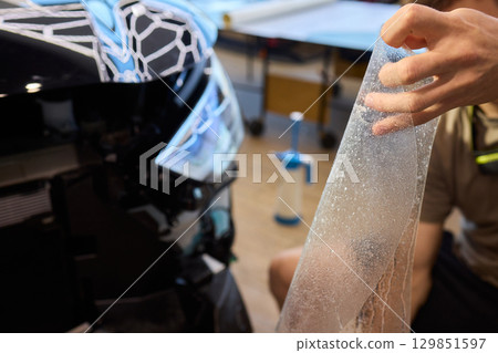 Applying a Protective Film on the Surface of Your Car for Enhanced Durability and Shine 129851597