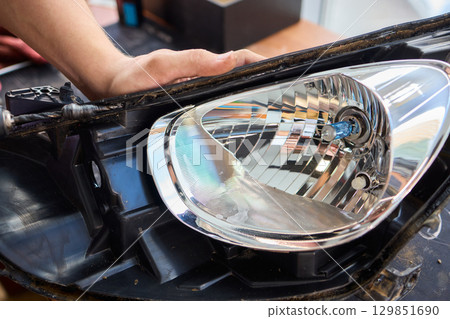 Careful precision is essential when installing a car headlight assembly for optimal performance Careful precision is essential when installing a car headlight assembly for optimal performance 129851690