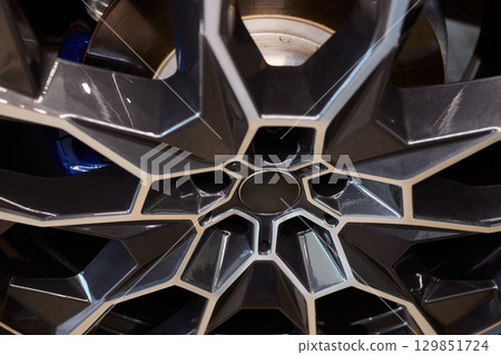 A CloseUp View of a Modern Car Alloy Wheel Design Featuring Intricate Geometric Patterns 129851724