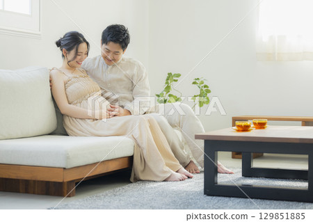 客廳裡的年輕夫婦,孕婦 客廳裡的年輕夫婦,孕婦 129851885